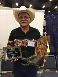 Ty May holding plaque and boots